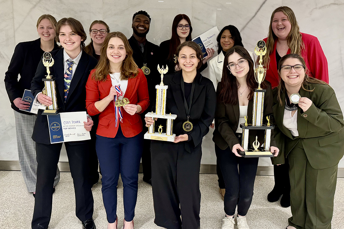 group of students holding trophies and awards